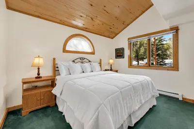 a bedroom with a white bed and a window at Bugle Pointe A14 by Estes Park Condos in Estes Park