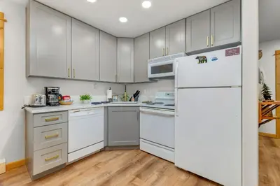 a kitchen with white cabinets and a refrigerator at Bugle Pointe A15 by Estes Park Condos in Estes Park
