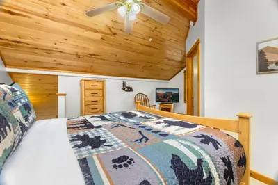 a bedroom with a bed with a wooden ceiling at Bugle Pointe A15 by Estes Park Condos in Estes Park
