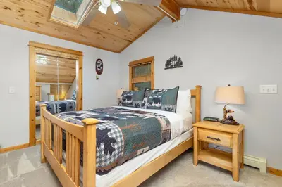 a bedroom with a bed and a table with a lamp at Bugle Pointe A15 by Estes Park Condos in Estes Park