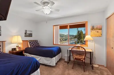 a bedroom with two beds and a window and a chair at Lagoon 723D by Great Western Lodging in Frisco