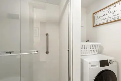 a white bathroom with a shower and a washing machine at Lake Cliffe A101 by Great Western Lodging in Dillon