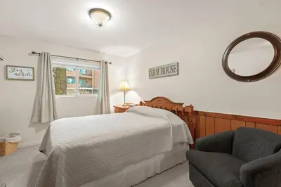 a bedroom with a bed and a chair and a mirror at Lake Cliffe A101 by Great Western Lodging in Dillon