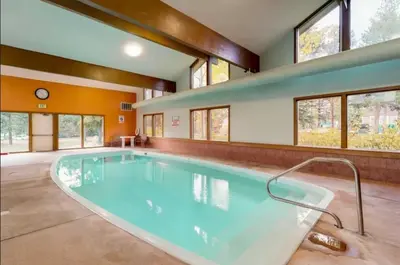 a large swimming pool in a room with windows at Lake Cliffe E201 by Great Western Lodging in Dillon