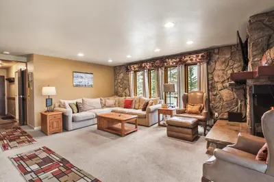a large living room with a stone wall at Lake Cliffe E201 by Great Western Lodging in Dillon