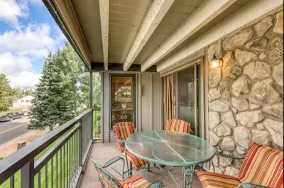 a patio with a glass table and chairs on a balcony at Lake Cliffe E201 by Great Western Lodging in Dillon