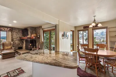 a kitchen and dining room with a table and a fireplace at Lake Cliffe E201 by Great Western Lodging in Dillon