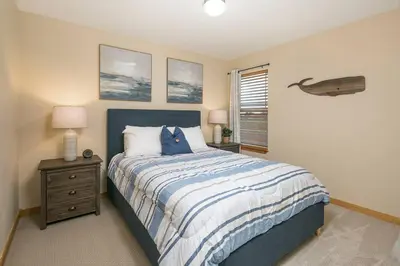 a bedroom with a bed with a blue and white comforter at Parkview Retreat in Windsor