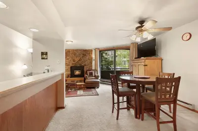 a kitchen and dining room with a table and a television at Marina Place 115 by Great Western Lodging in Dillon