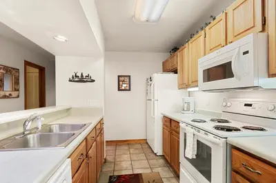 a kitchen with white appliances and wooden cabinets at Marina Place 115 by Great Western Lodging in Dillon