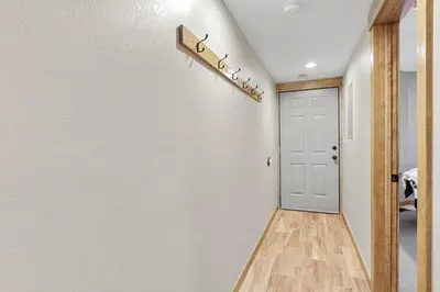 a hallway with a white wall and a door at Mountain View Getaway by Great Western Lodging in Frisco
