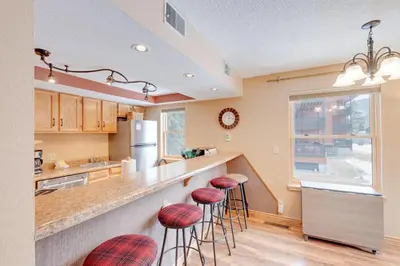 a kitchen with bar stools and a counter top at Mountainside B173 by Great Western Lodging in Frisco