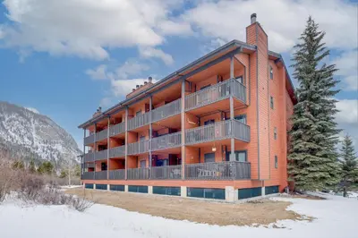 a large orange building with balconies in the snow at Mountainside B173 by Great Western Lodging in Frisco