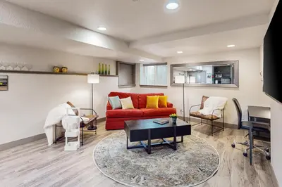 a living room with a red couch and a table at Easy Commuting! Renovated Greeley Apartment in Greeley