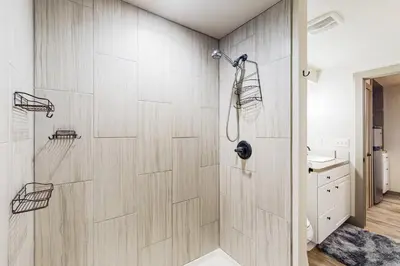 a shower in a bathroom with a wooden wall at Easy Commuting! Renovated Greeley Apartment in Greeley