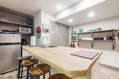 a kitchen with a counter with stools and a refrigerator at Easy Commuting! Renovated Greeley Apartment in Greeley