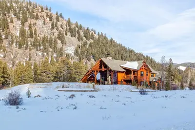 a log cabin in the snow with a mountain at The Observatory by Great Western Lodging in Breckenridge