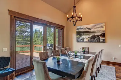 a dining room with a table and chairs and a balcony at The Observatory by Great Western Lodging in Breckenridge