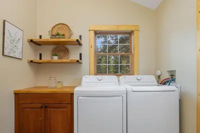 a laundry room with two washing machines and a window at Antlers Pointe 1 by Estes Park Condos in Estes Park