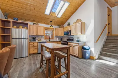 a kitchen with wooden cabinets and a table and a refrigerator at Antlers Pointe 1 by Estes Park Condos in Estes Park