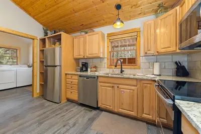 a kitchen with wooden cabinets and a stainless steel refrigerator at Antlers Pointe 1 by Estes Park Condos in Estes Park