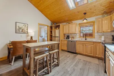 a kitchen with wooden cabinets and a table and chairs at Antlers Pointe 1 by Estes Park Condos in Estes Park