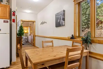 a kitchen and dining room with a wooden table and chairs at Bugle Pointe A02 by Estes Park Condos in Estes Park