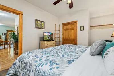 a bedroom with a bed with a blue and white comforter at Bugle Pointe A02 by Estes Park Condos in Estes Park