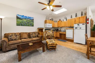 a living room with a couch and a kitchen at Bugle Pointe A02 by Estes Park Condos in Estes Park