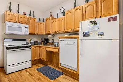 a kitchen with white appliances and wooden cabinets at Bugle Pointe A02 by Estes Park Condos in Estes Park