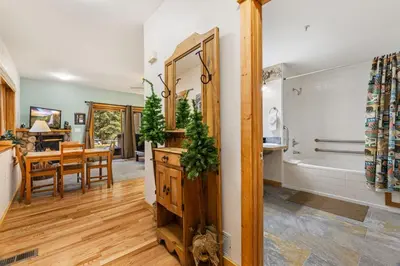 a bathroom with a tub and a dining room with a table at Bugle Pointe A02 by Estes Park Condos in Estes Park