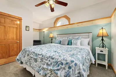 a bedroom with a bed and a ceiling fan at Bugle Pointe A02 by Estes Park Condos in Estes Park