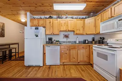 a kitchen with white appliances and wooden cabinets at Bugle Pointe B10 by Estes Park Condos in Estes Park
