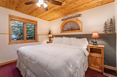a bedroom with a large bed and a ceiling fan at Bugle Pointe B10 by Estes Park Condos in Estes Park