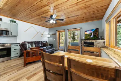 a living room with a ceiling fan and a table at Bugle Pointe B12 by Estes Park Condos in Estes Park