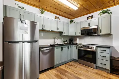 a kitchen with stainless steel appliances and white cabinets at Bugle Pointe B12 by Estes Park Condos in Estes Park