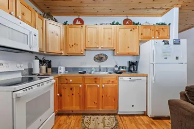 a kitchen with white appliances and wooden cabinets at Bugle Pointe B18 by Estes Park Condos in Estes Park