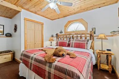 a teddy bear laying on a bed in a bedroom at Bugle Pointe B18 by Estes Park Condos in Estes Park
