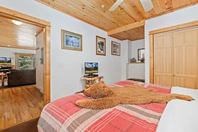 a teddy bear laying on a bed in a bedroom at Bugle Pointe B18 by Estes Park Condos in Estes Park