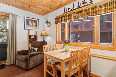 a living room with a table and a chair at Bugle Pointe B18 by Estes Park Condos in Estes Park