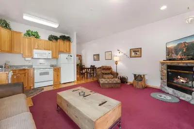 a kitchen and living room with a table in a room at Bugle Pointe A16 by Estes Park Condos in Estes Park