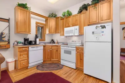 a kitchen with white appliances and wooden cabinets at Bugle Pointe A16 by Estes Park Condos in Estes Park