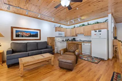 a living room with a couch and a kitchen at Bugle Pointe B14 by Estes Park Condos in Estes Park