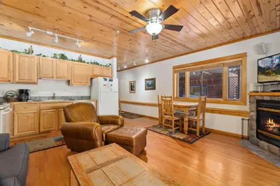 a kitchen and living room with a table and a fireplace at Bugle Pointe B14 by Estes Park Condos in Estes Park