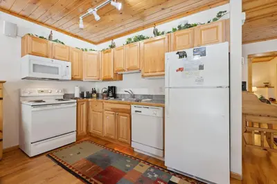 a kitchen with white appliances and wooden cabinets at Bugle Pointe B14 by Estes Park Condos in Estes Park