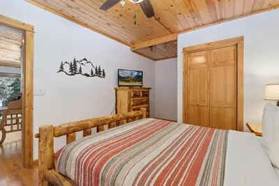 a bedroom with a bed and a wooden door at Bugle Pointe B14 by Estes Park Condos in Estes Park