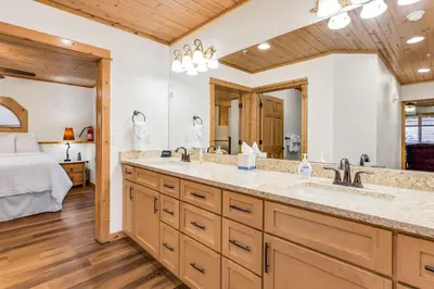 a bathroom with a double sink and a bed at Bugle Pointe B20 by Estes Park Condos in Estes Park