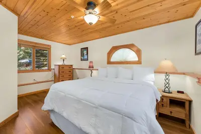 a bedroom with a white bed and a wooden ceiling at Bugle Pointe B20 by Estes Park Condos in Estes Park