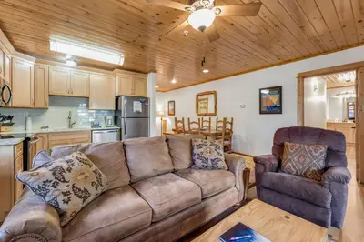 a living room with a couch and a kitchen at Bugle Pointe B20 by Estes Park Condos in Estes Park