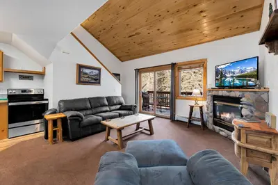 a living room with a couch and a fireplace at Bugle Pointe A03 by Estes Park Condos in Estes Park
